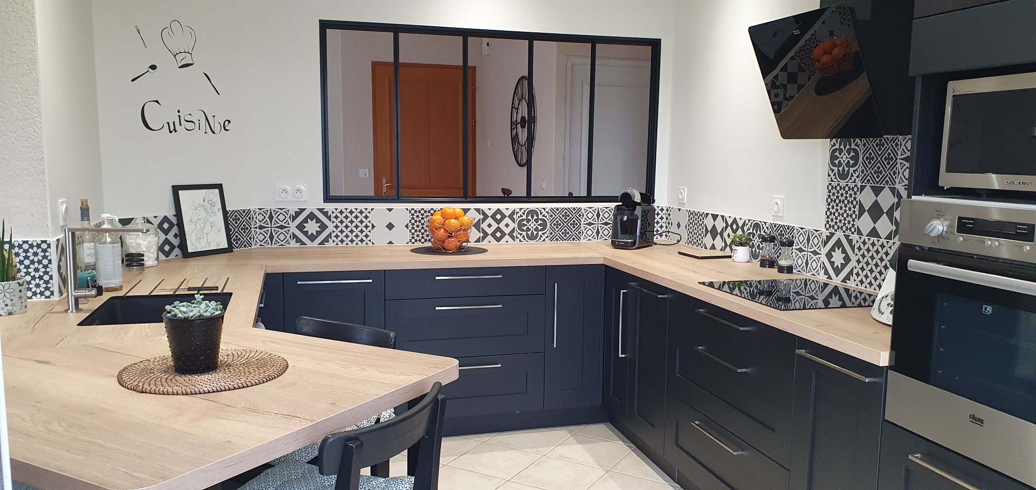 Cuisine équipée sur mesure avec électroménager encastré et verrière intérieure en Vendée.