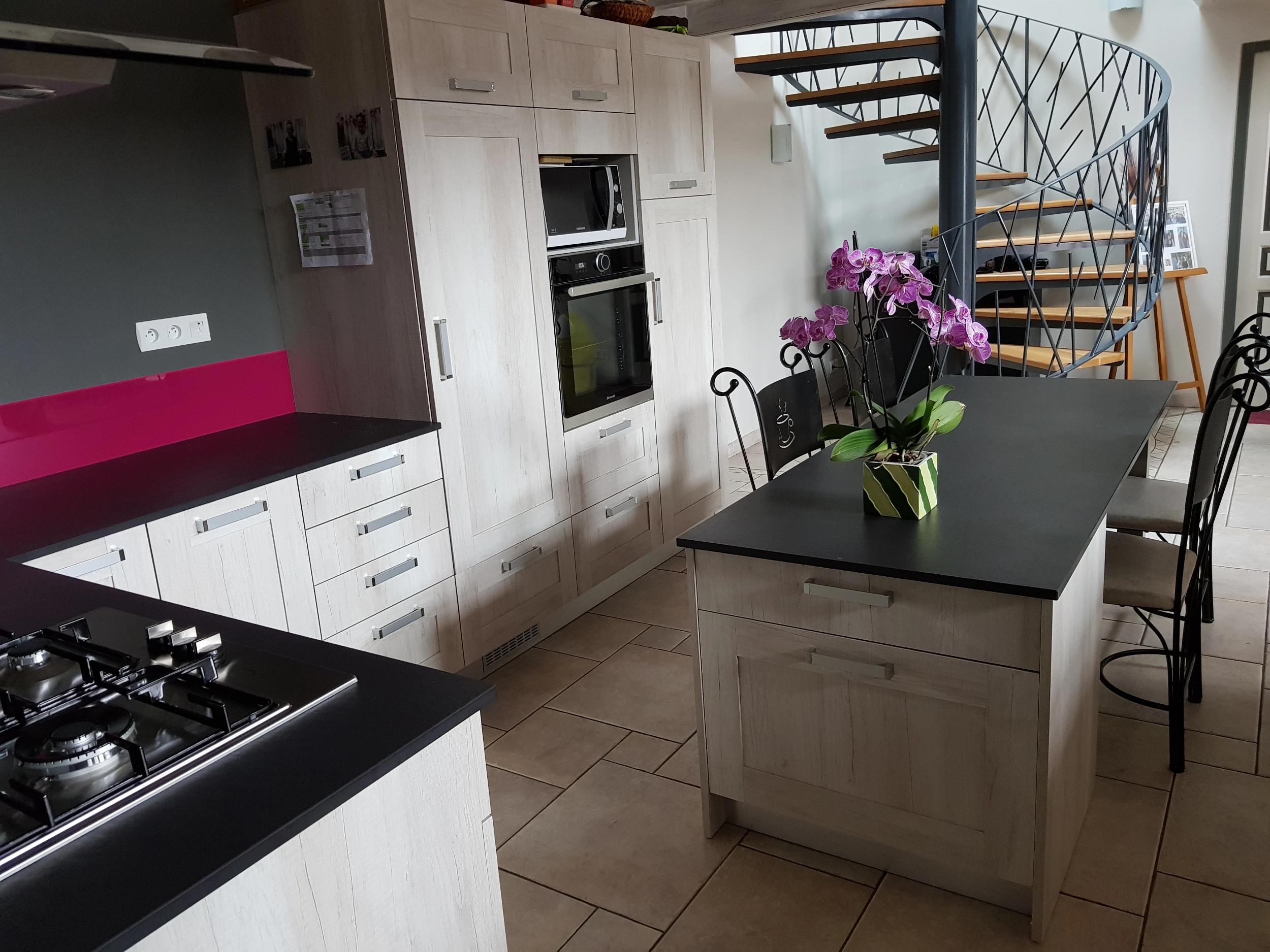 Cuisine équipée contemporaine avec îlot central et colonne de rangement encastrée en Vendée.