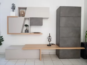 Ensemble de mobilier de salon avec des blocs de rangement muraux suspendus gris et beige, une étagère en bois clair et une lampe design posée sur le plateau.