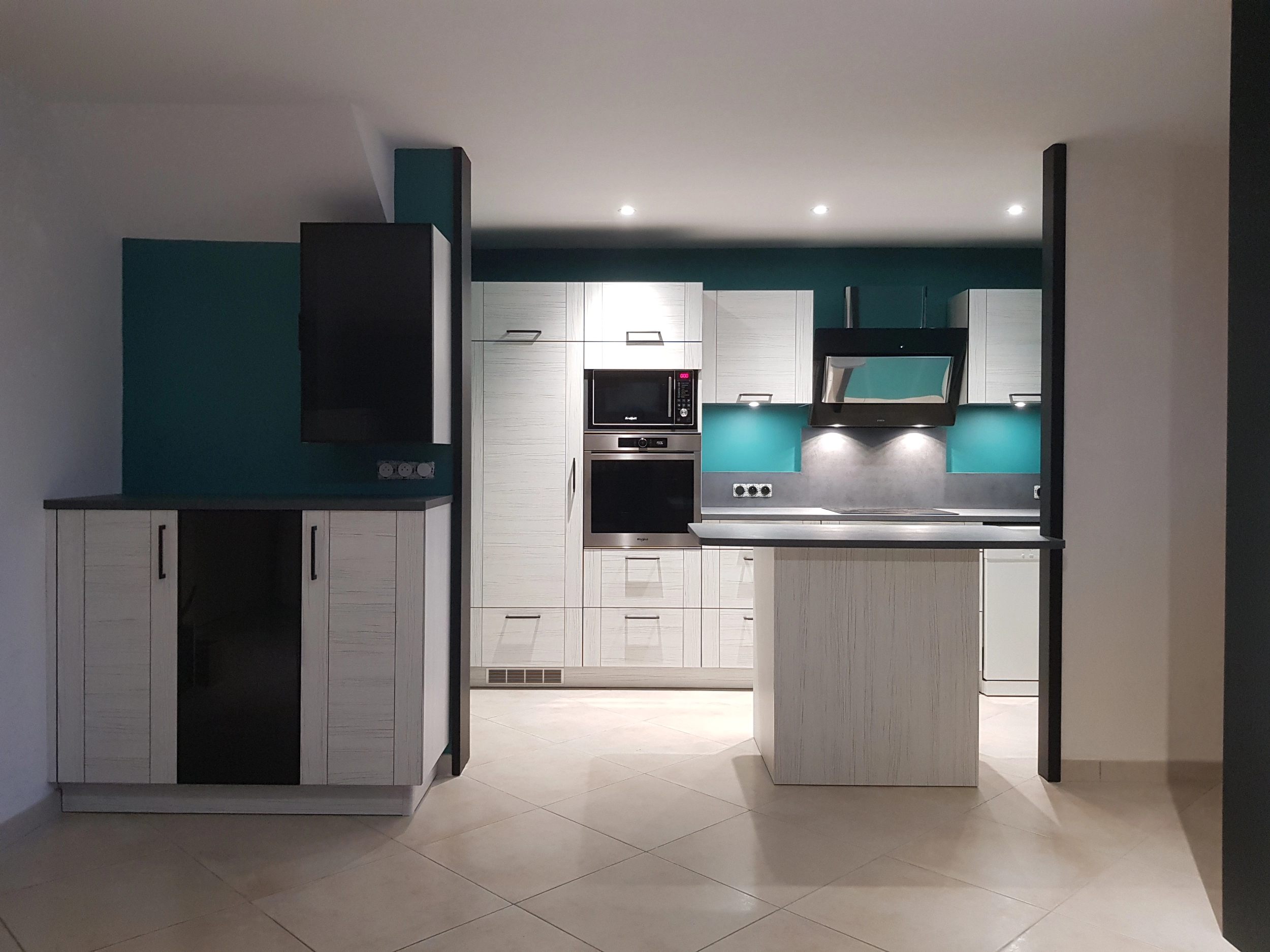 Grande cuisine avec de très nombreux rangements. Façades de placard imitation rainure de bois blanc