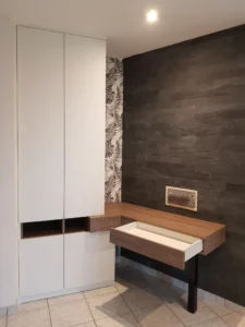 Focus sur un large tiroir en bois ouvert intégré sous le plateau d'un meuble de bureau suspendu contemporain.