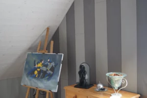 Pose de lambris bois bicolore gris et blanc sur un mur mansardé pour l'aménagement d'une médiathèque.